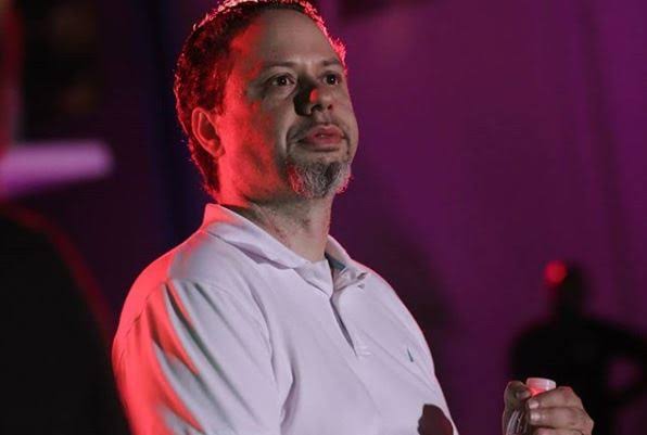 Original photograph of Tristan Desechenes in a white shirt under red and purple lighting